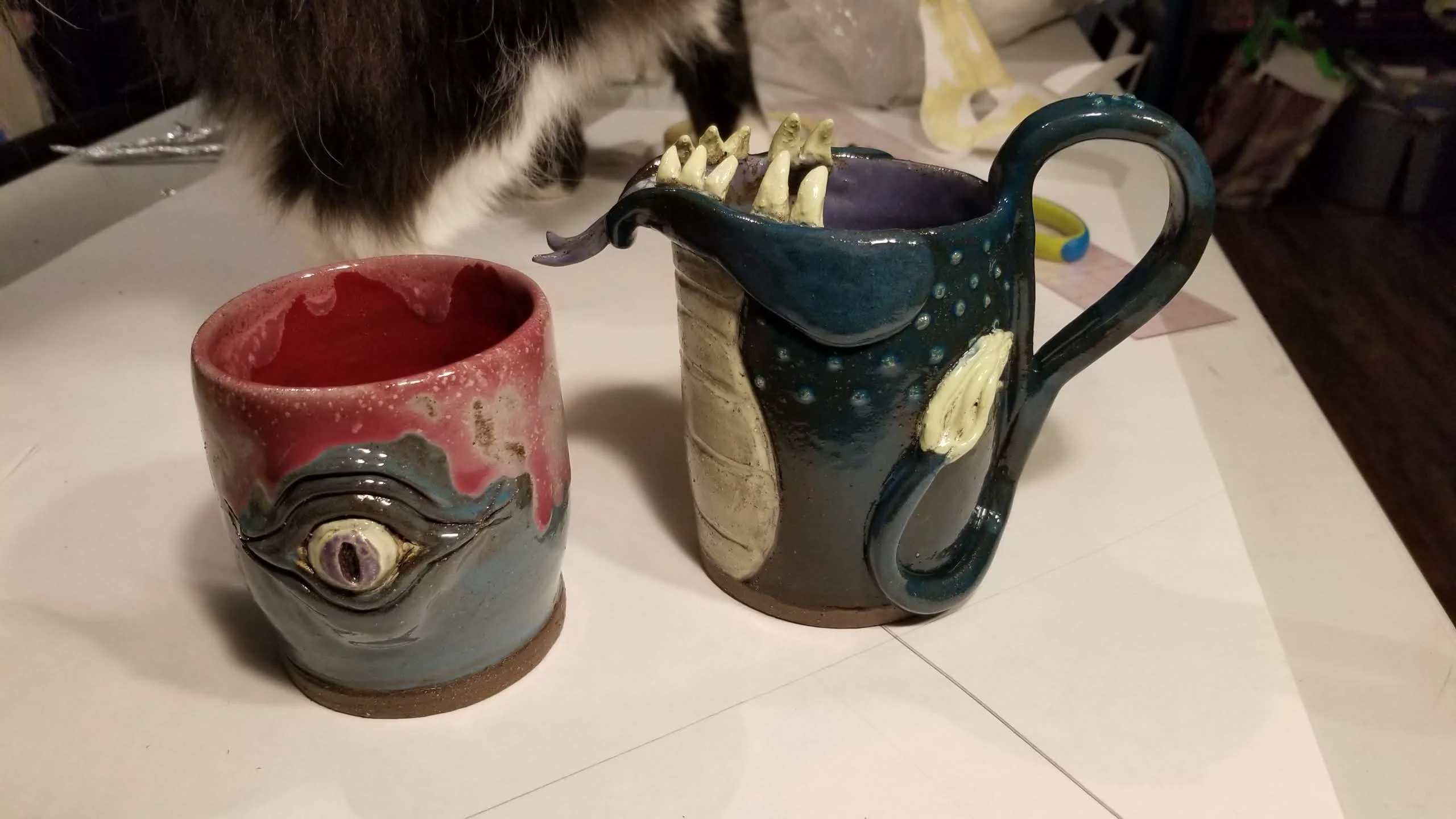 Collection of handmade monster-themed ceramic vessels